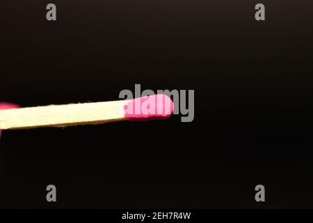 One wooden match, close-up, on a black background. Stock Photo