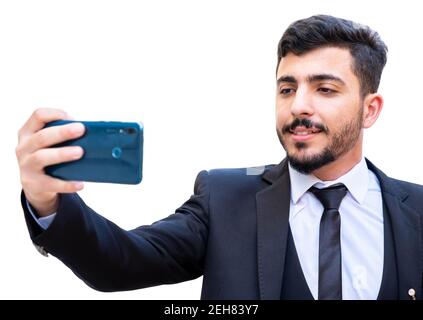 Man wearing suit and taking selfie with his mobile phone while smiling and outfitted Stock Photo