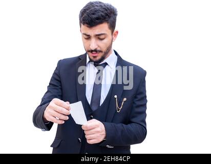 Arabic man wearing suit holding an invoice and checking the sum of the items that he bought from the supermarket Stock Photo
