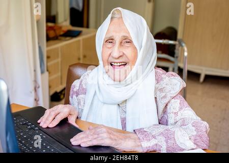 Old woman using laptop for working and communicating Stock Photo