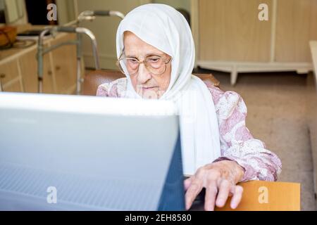 Old woman using laptop for working and communicating Stock Photo