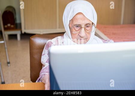 Old woman using laptop for working and communicating Stock Photo