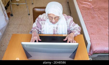 Old woman using laptop for working and communicating Stock Photo