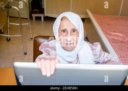 Old woman using laptop for working and communicating Stock Photo