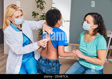 Mother and son child auscultating doctor chest at clinic Stock Photo ...