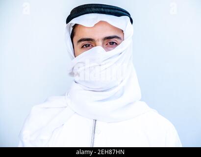 Arabic young man masking his face with hatta Stock Photo