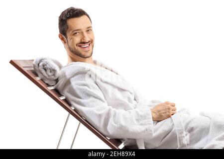 Man in a bathrobe relaxing on a lounge chair and smiling at the camera isolated on white background Stock Photo