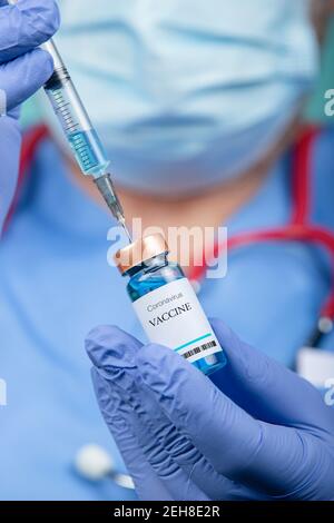 The doctor holds the syringe and the Covid-19 Medicine vaccine vials concept. Vertical picture Stock Photo