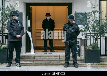 LONDON, UK 19 February 2021. Police officers and a doorman in a top hat guard the front door of the King Edward VII hospital where  HRH Prince Philip, Duke of Edinburgh aged 99 years old  has been receiving medical treatment as a precautionary measure since  being admitted to hospital on 16th February after feeling unwell. Credit amer ghazzal/Alamy Live News Stock Photo
