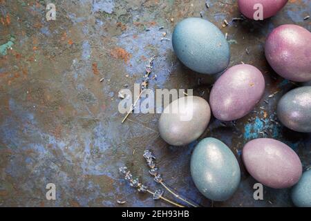 Colorful pastel easter eggs on dark stone background with space for text, top view. Stock Photo