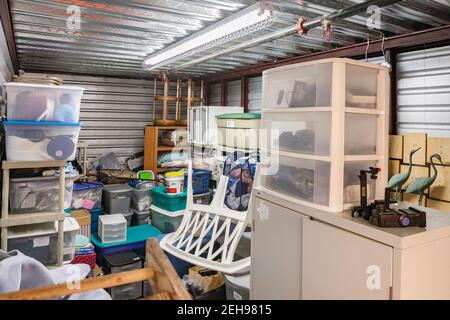 Messy interior of self storage unit at an enclosed mini warehouse facility Stock Photo