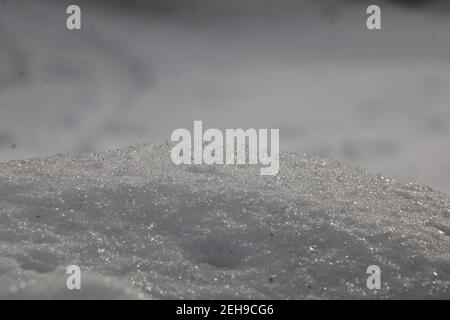 Snow in foreground, on raised surface, with blurred snow in background Stock Photo