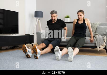 Couple Doing Home Fitness Workout And Exercise Stock Photo