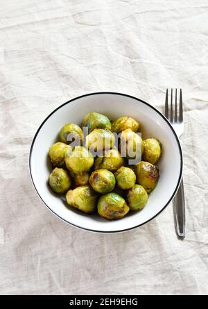 Roasted brussles sprouts in bowl over light background with free text space. Stock Photo
