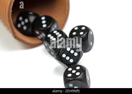 Black dice and dice cups against a white background Stock Photo