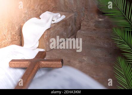 Palm leaves on a empty Tomb and Wooden cross over open bible background with copy space for inscription. Concept of Jesus entering Jerusalem and Chris Stock Photo