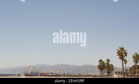 California beach aesthetic, classic ferris wheel, amusement park on pier, Santa Monica pacific ocean resort. Summertime iconic view, palm trees and sk Stock Photo