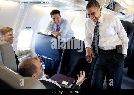 President Barack Obama jokes with Ben Rhodes, Deputy National Security Advisor for Strategic Communication, aboard Air Force One en route from London, England, to the G8 Summit in Deauville, France, May 26, 2011. Mike McFaul, Senior Director for Russian and Central Asian Affairs, left, and Director of Communications Dan Pfeiffer laugh with them. Stock Photo