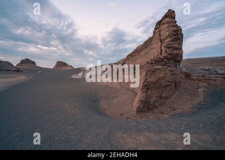 Early morning in the bizzare landscape of Lut desert, the hottest place on earth. Bizzare geological shapes rise from sand and dirt. Stock Photo