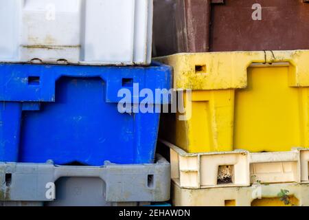 Multi colored plastic cargo crates stacked up on top of each other Stock Photo