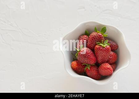 Red, Ripe Strawberries Fresh From the Garden in White Bowl on White Textured Background Stock Photo