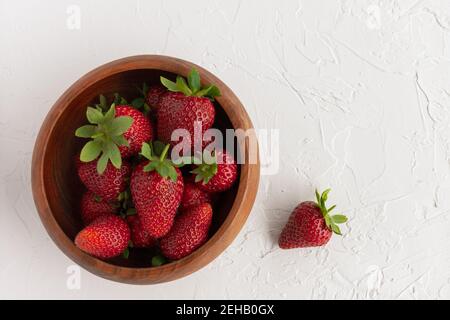 Wooden Bowl of Red, Ripe Strawberries Fresh From the Garden on White Textured Background Stock Photo
