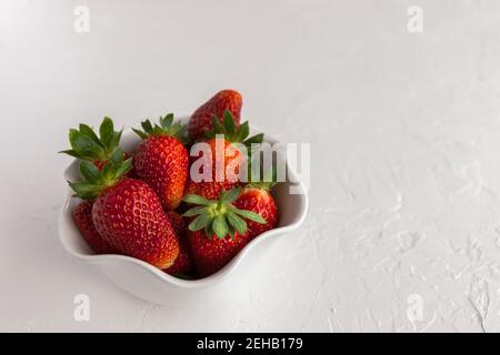 Bowl of Red, Ripe Strawberries Fresh From the Garden on White Textured Background Stock Photo