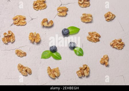 Fresh blueberries and shelled walnuts on a gray background. Natural products concept. High quality photo Stock Photo