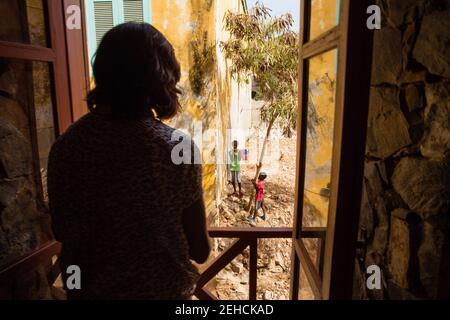 First Lady Michelle Obama looks out a window at local children during her visit to a cultural center on Gorée Island, Senegal, June 27, 2013. Stock Photo