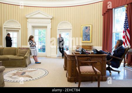 President Barack Obama talks on the phone with AFL-CIO President Richard Trumka during a call in the Oval Office, Aug. 21, 2013. Listening from left are: Rob Nabors, Deputy Chief of Staff for Policy; Alyssa Mastromonaco, Deputy Chief of Staff for Operations; and Chief of Staff Denis McDonough. Stock Photo