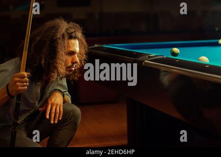 Crop focused bearded male playing game in billiard pool Stock Photo