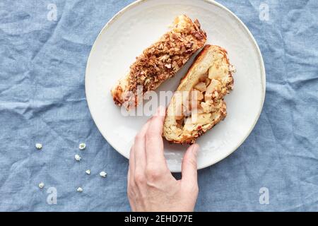 From above of crop anonymous person with pieces of delicious apple pastry with crunchy pecan nuts on top Stock Photo