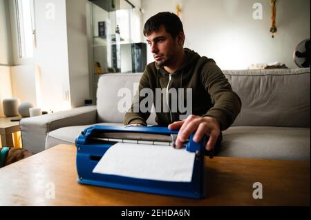 Visually impaired male typing on typewriter with tactile writing system at home Stock Photo
