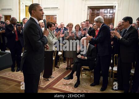 President Barack Obama looks on as attendees applaud Vice President Joe Biden during a meeting with the House Democratic Caucus in the East Room of the White House, Feb. 4, 2014. Stock Photo