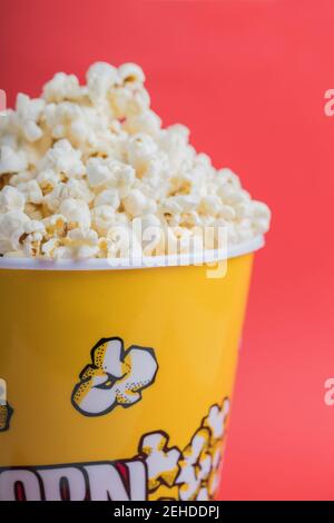 Bowl full of popcorn on a red background Stock Photo