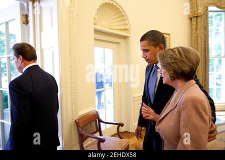 President Barack Obama escorts Speaker of the House Nancy Pelosi (D-Calif) from the Oval Office to the Rose Garden for the announcement of new fuel and emission standards for cars and trucks.  At left is Governor Arnold Schwarzenegger (R-Calif). Stock Photo