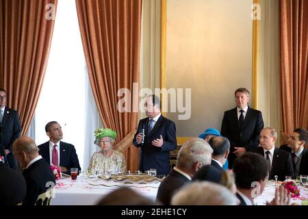 President François Hollande of France speaks during a lunch to commemorate the 70th anniversary of D-Day, at  Château de Bénouville in Normandy, France, June 6, 2014. Seated from left are: President Barack Obama, Queen Elizabeth II of the United Kingdom, Queen Margrethe of Denmark and President Vladimir Putin of Russia. Stock Photo