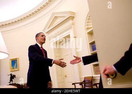 President Barack Obama shakes hands with a guest entering the Oval Office, May 20, 2009. Stock Photo