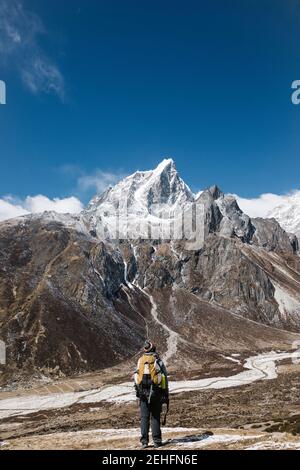 Man standing in front of a snow capped mountain, HImalayas, Nepal Stock Photo