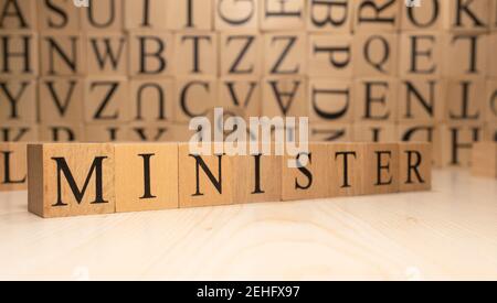 The word minister is from wooden cubes. Economy state government terms. Background made of wooden letters. Stock Photo