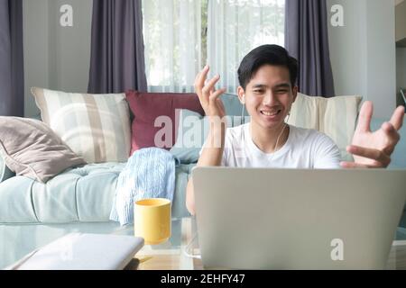 Young man working and learning online at home. Young man video call conference online with his colleagues. Stock Photo