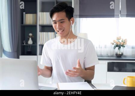 Young man working and learning online at home. Young man video call conference online with his colleagues. Stock Photo