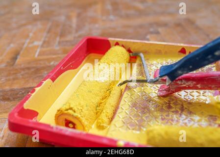 Painted wall and painting supplies ,roller, brush, tray liner and paint. Stock Photo