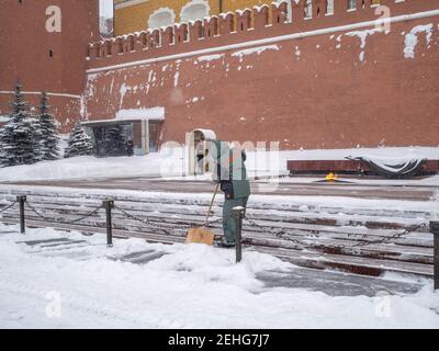 Moscow. Russia. February 12, 2021. Utility workers remove snow with shovels during a snowfall near the Kremlin wall at the grave of the Unknown Stock Photo