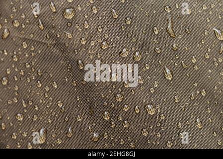 Drops of rain, water on a waterproof fabric close-up. Tent with raindrops. Stock Photo