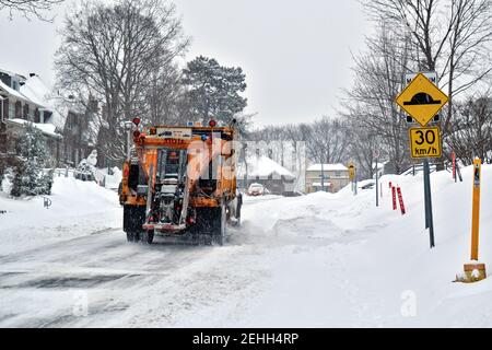 Life in a cold city - winterscapes from Ottawa - orange city snow plow truck clearing fresh snow on Lakeview Ave. Ontario, Canada. Stock Photo