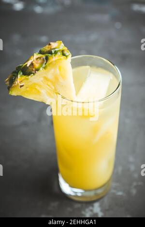 Fresh pineapple beverage on rustic background. Selective focus. Shallow depth of field. Stock Photo