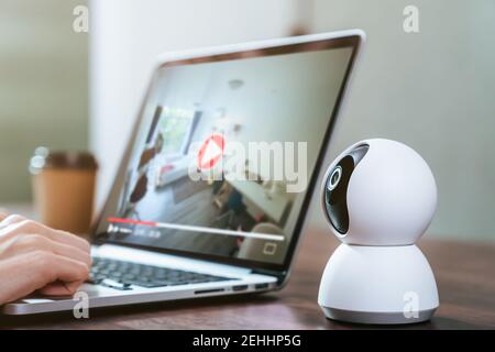 Security CCTV camera on the table and using laptop with looking video record, surveillance technology. Stock Photo