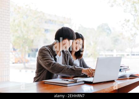 High school or college students  group catching up workbook and learning tutoring on desk and reading, doing homework, lesson practice preparing exam. Stock Photo