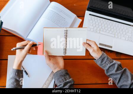 High school or college students  group catching up workbook and learning tutoring on desk and reading, doing homework, lesson practice preparing exam. Stock Photo